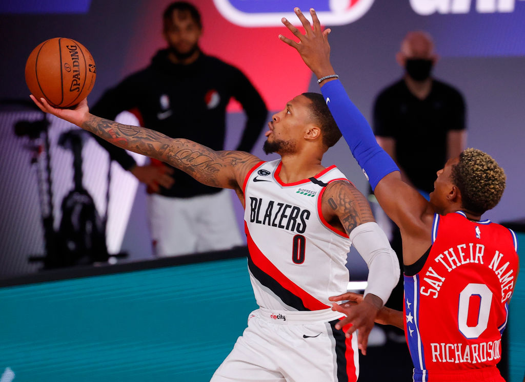 LAKE BUENA VISTA, FLORIDA - AUGUST 09: Damian Lillard #0 of the Portland Trail Blazers goes up for a shot against Josh Richardson #0 of the Philadelphia 76ers at Visa Athletic Center at ESPN Wide World Of Sports Complex on August 09, 2020 in Lake Buena Vista, Florida